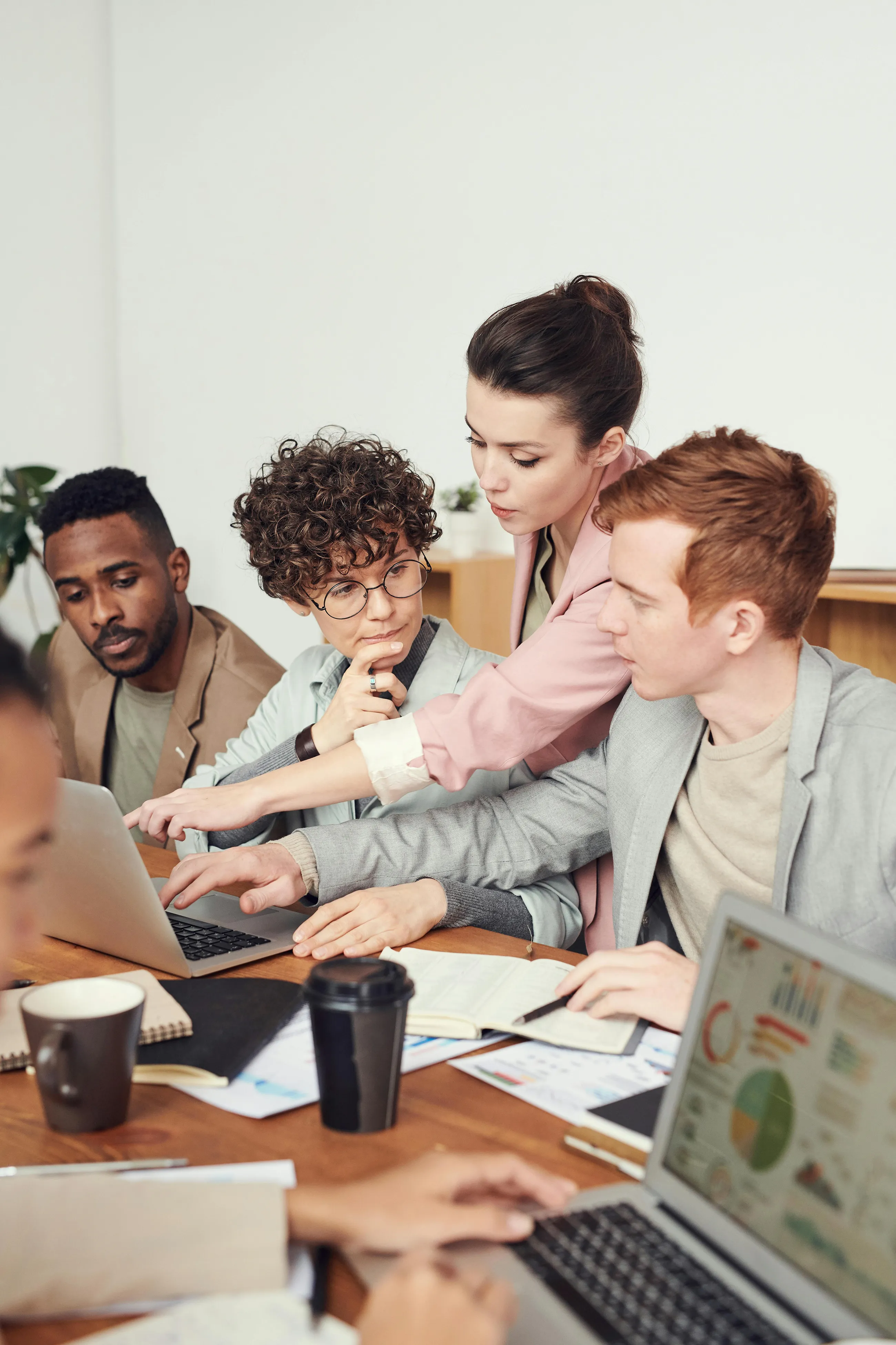 Business team collaborating around laptops and reports during a working session