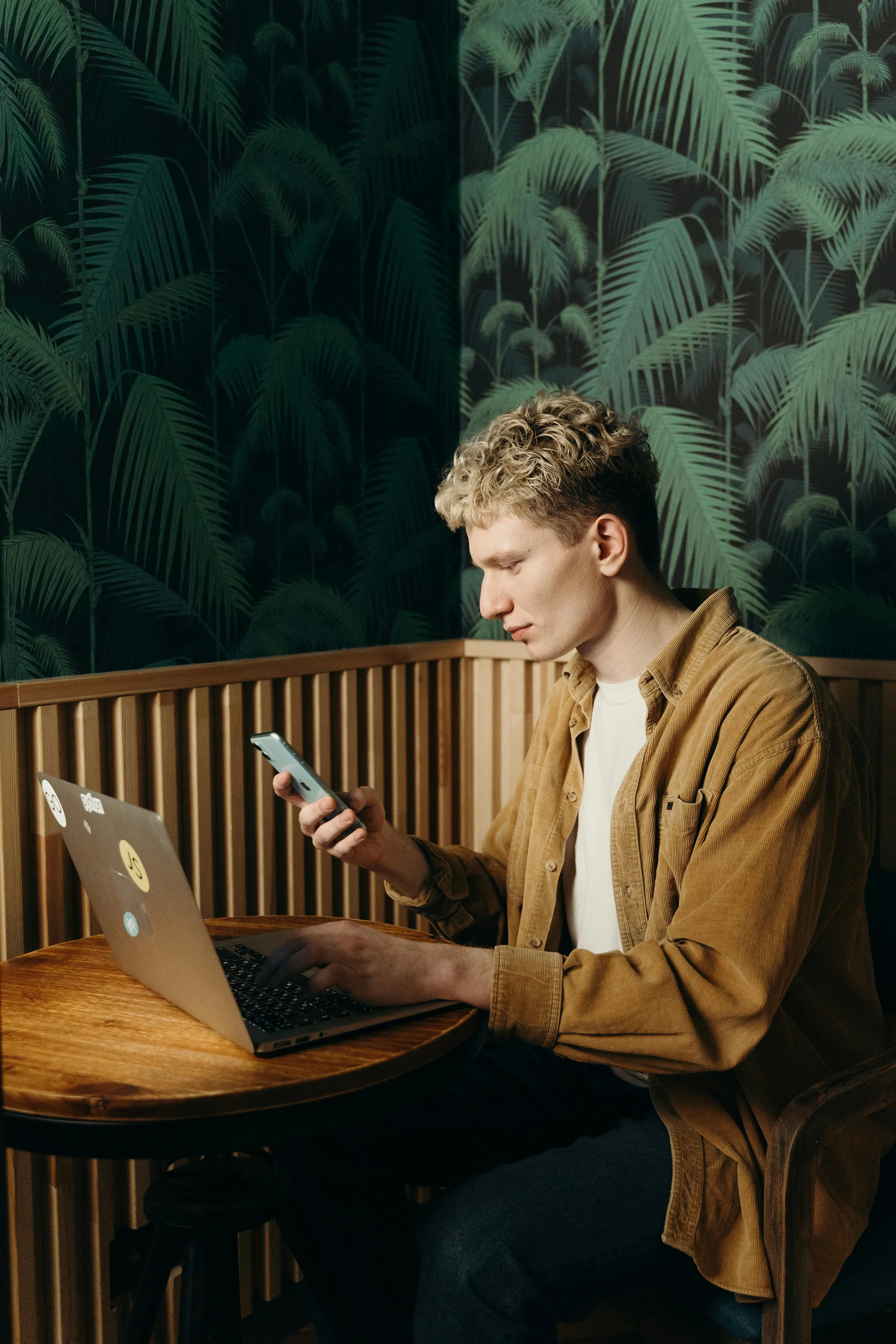 Professional working with a laptop and phone in a cafe setting